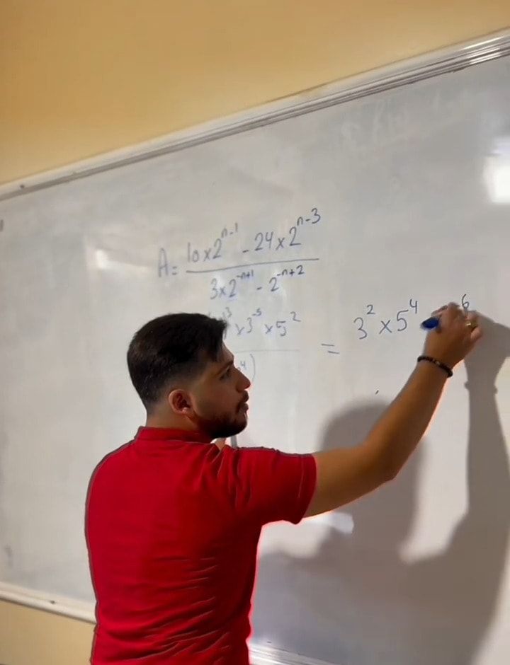 An iLearn teacher working through a maths problem on the whiteboard